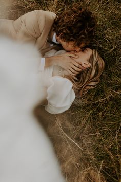 a woman laying in the grass with her head on her chest