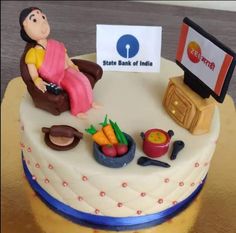 a cake with a woman sitting in a chair and food on the table next to it