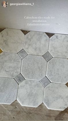 some white and grey hexagonal tiles on the floor in front of a box