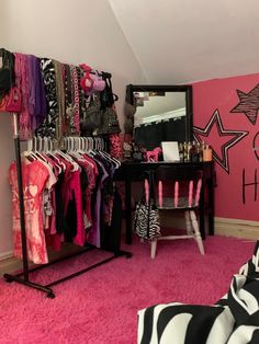 a room with pink carpet, zebra print rug and clothes hanging on the wall in front of a mirror