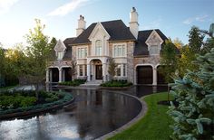 a large house with lots of windows next to a pond