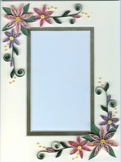 a white frame decorated with flowers and leaves