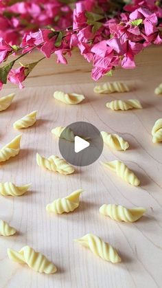 the video is showing how to make pasta shells with flowers in the background and cut into smaller pieces