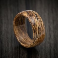 a wooden ring on top of a black table with wood inlayed to it