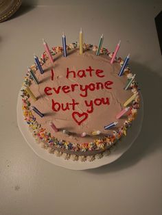 a birthday cake with candles on it that says i hate everyone but you love me