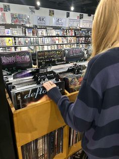 a woman looking at cds in a store