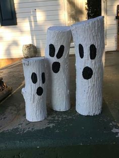 three white logs with faces painted on them