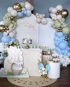 a table with balloons and decorations on it for a baby's first birthday party