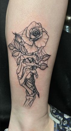 a woman's leg with a rose tattoo on the side of her body and hands holding roses