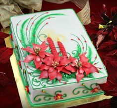 a cake decorated with poinsettis and green leaves