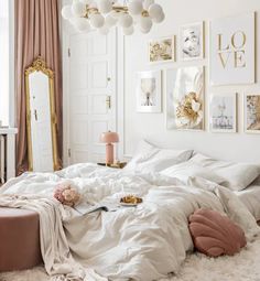 a bedroom with white bedding and pictures on the wall above it, along with a pink ottoman