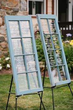 two blue framed signs sitting in the grass