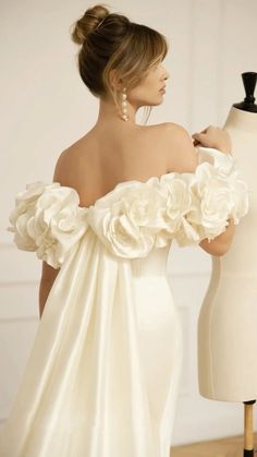 the back of a woman's wedding dress with flowers on her shoulders and shoulder