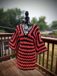 a black and red dress on a wooden deck