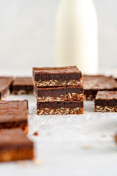 several pieces of brownie sitting on top of a table next to a bottle of milk