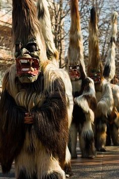 a group of people dressed in costume walking down the street with their hands on their hipss