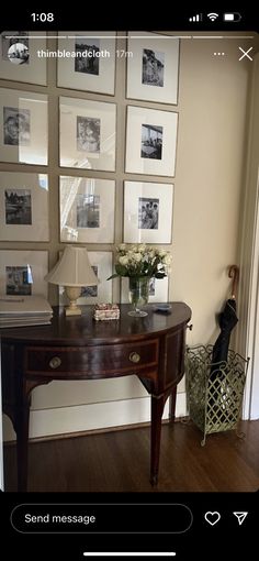 a wooden table sitting in front of a wall with pictures on it