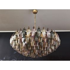 a chandelier hanging from the ceiling with many different colored glass pieces on it