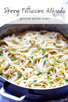 a skillet filled with pasta and parsley on top of a stove next to the words skinnyy fettuccine alfredo