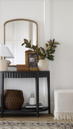 a black table with a mirror and some plants on it