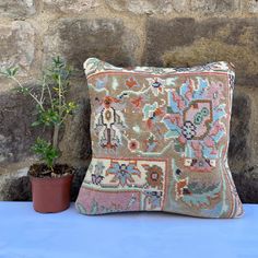 a small potted plant sitting next to a decorative pillow