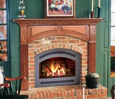 a living room with a fire place in the center and pictures on the wall above it