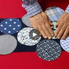 a person cutting out paper circles on top of a table