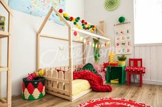 a child's bedroom decorated in red, white and green with a doll house bed