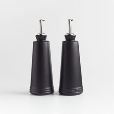 two black salt and pepper shakers on a white background