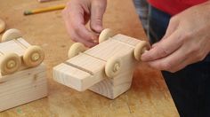 a person is making wooden toys on a table