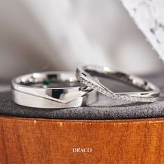 two wedding rings sitting on top of a wooden box