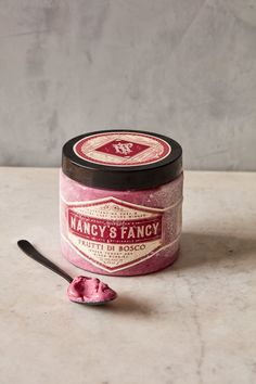 a spoon is sitting next to a jar of fancy and fancy pink icecream