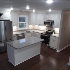 an empty kitchen with white cabinets and stainless steel appliances