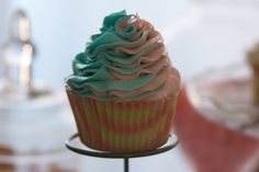 a cupcake with frosting on a metal stand