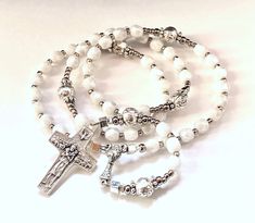 "This one of a kind small handmade catholic rosary would make a great first communion gift. The Ave beads are 5mm luster white faceted glass beads. The Pater beads are 6mm oxidized silver roses. The 14mm ( 5/8\") oxidized silver center shows a communion chalice with host. Double sided. The 30mm ( 1.25\" ) oxidized silver cross has the Good Shepherd. Total length of the rosary: 12.5\", 31cm Circumference of the upper part: 13\" (42cm) All my rosaries and jewelry are guaranteed one of a kind, whic White Crucifix Necklace For Gift, Spiritual White Cross Jewelry, 8mm Bead Crucifix For First Communion, 8mm Bead Crucifix Jewelry For First Communion, White Spiritual Rosary Bracelet, White Spiritual Rosary Bracelet With 8mm Beads, Pearl White Rosary With 8mm Beads As Gift, Adjustable White Rosary Bracelet Gift, Spiritual Cross Rosary Bracelet For Baptism