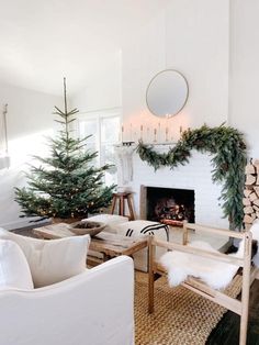 a living room filled with furniture and a fire place covered in christmas tree garlands