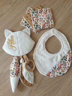 three bibs, one with a name on it and the other with a monogrammed bib