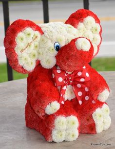 a red and white teddy bear sitting on top of a table