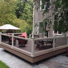 a deck with chairs and an umbrella next to a house