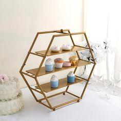 a shelving unit with cupcakes on it in front of a cake stand