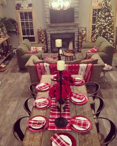 a dining room table set for christmas with red and white plaid napkins on it