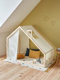 a child's bed in the corner of a room with a tent on it