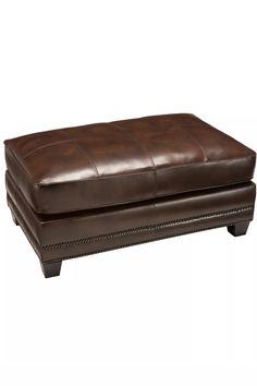 a brown leather ottoman sitting on top of a white floor