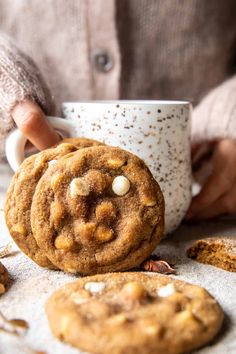 a person holding a coffee cup and some cookies