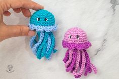 two crocheted octopus toys sitting next to each other on a white counter top