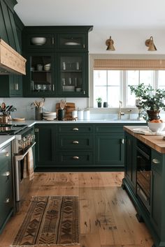 a kitchen with dark green cabinets and wooden floors is pictured in this image from the front view