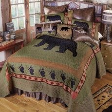 a bed with a bear and paw prints on the comforter is shown in front of a window