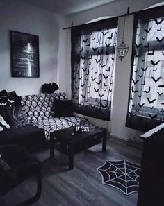 a living room filled with furniture and bats on the curtains