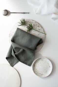 a white plate topped with green napkins next to a spoon