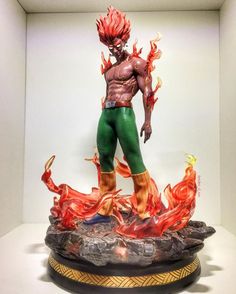 an action figure is displayed in a glass case with flames coming out of the body